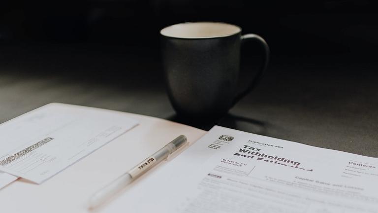 Tax return forms with coffee mug